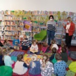 Grupa dzieci w bibliotece podczas głośnego czytania