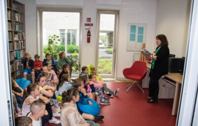 Dzieci w bibliotece słuchają pisarki