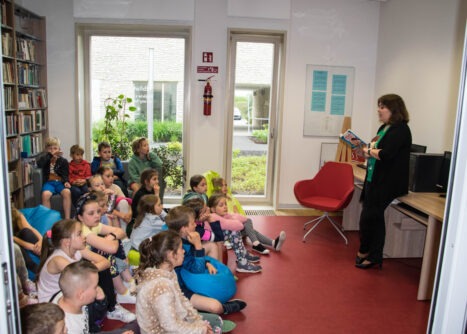 Dzieci w bibliotece słuchają pisarki